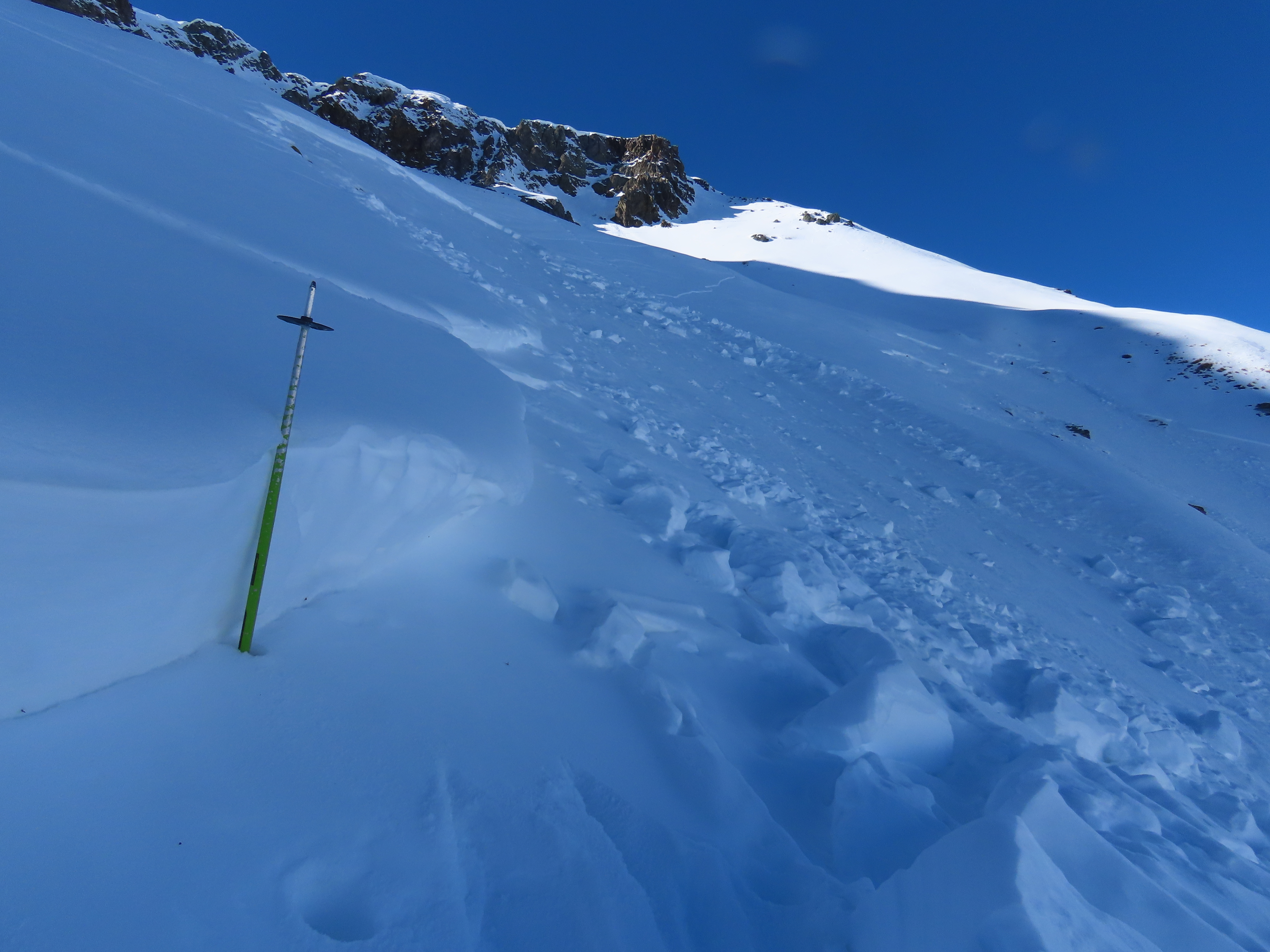 Looking at a ski pole by the crown of an avalanche