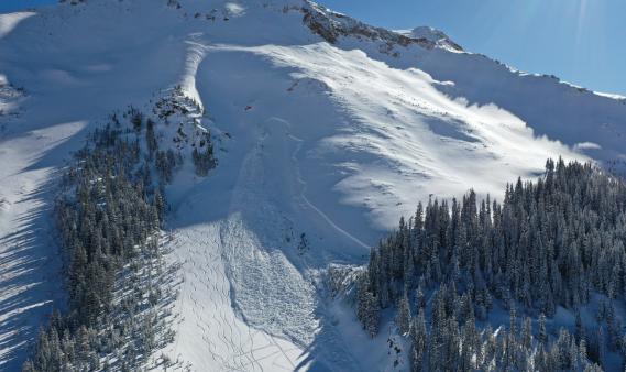 Large avalanche with many ski tracks to the lookers left of it. 